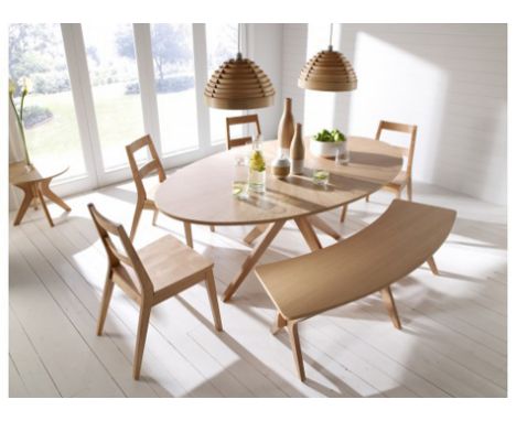 Oval light oak dining table on centre quadruple base, together with four matching panel seat chairs and a shaped bench.  Tabl