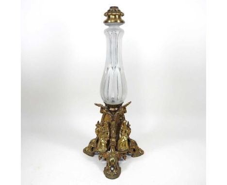 An ornate 19th century brass lamp base, the gilt metal base decorated with a lady before a castle, on griffin supports, below