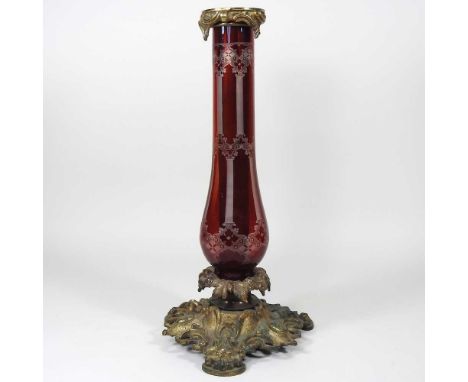 An ornate 19th century gilt spelter and ruby glass candle lamp base, on an ornate scrolled base, 39cm high