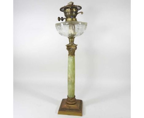 An early 20th century brass and onyx oil lamp, in the form of a Corinthian column, with a star cut glass reservoir, 58cm high