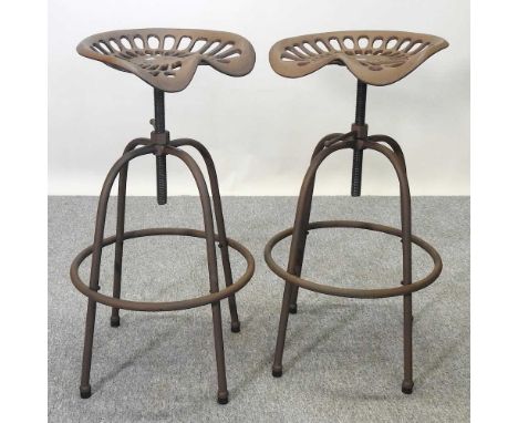 A pair of metal revolving bar stools, with tractor seats, (2)