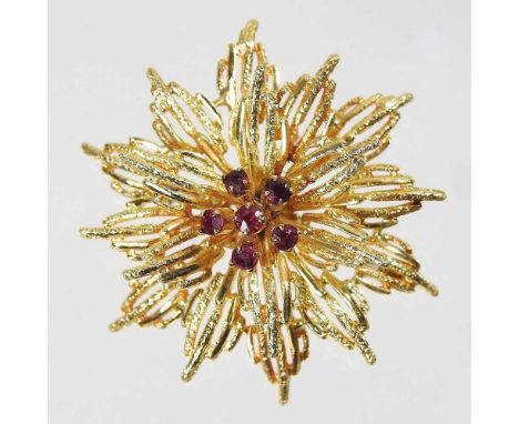 A ruby set flowerhead brooch, with ruby set stamen, on a pin back, stamped 18ct, 10.3g, 4cm diameter, boxed