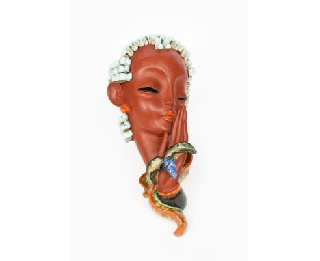 A large Goldscheider Pottery wall mask, model no. 7608, her hand raised up holding up a flower, with pale blue curly hair, in