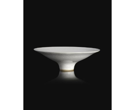 ‡Dame Lucie Rie (1902-1995) a porcelain footed bowl, low conical form covered to the foot in a white pitted glaze, impressed 