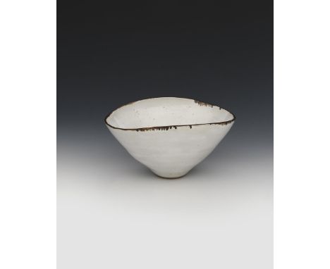‡Dame Lucie Rie (1902-1995) a stoneware elliptical bowl, footed form, glazed with a pitted white glaze with manganese rim, im