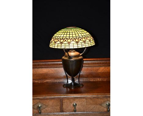 'Pomegranate' a Tiffany Studios patinated metal table lamp with leaded glass shade,  the domed shade with a band of mottled a