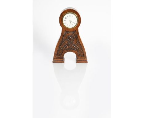 An Art Nouveau Liberty &amp; Co Romsdal oak mantle clock, the tapering body carved with entrelac motif, circular dial with Ar