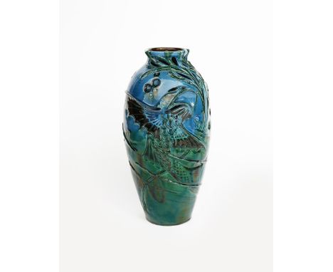 An Art Nouveau C H Brannam vase by Frederick Braddon, dated 1910, slender, shouldered form, pieced and modelled in low relief