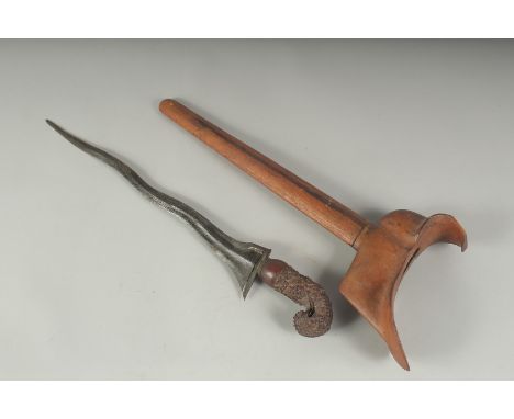 A INDONESIAN KRIS DAGGER, with carved wood handle and scabbard, and wavey blade, 48cm long.