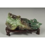 A CHINESE CARVED JADE FIGURE OF AN ELEPHANT ON A FITTED CARVED HARDWOOD STAND, figure 14cm long.