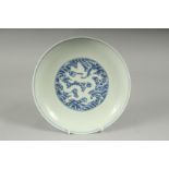 A CHINESE BLUE AND WHITE PORCELAIN DRAGON PLATE, with incised white dragon on stylised waves, six-