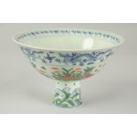 A CHINESE WUCAI PORCELAIN STEM CUP, painted with ducks and aquatic flora, bowl 17cm diameter.