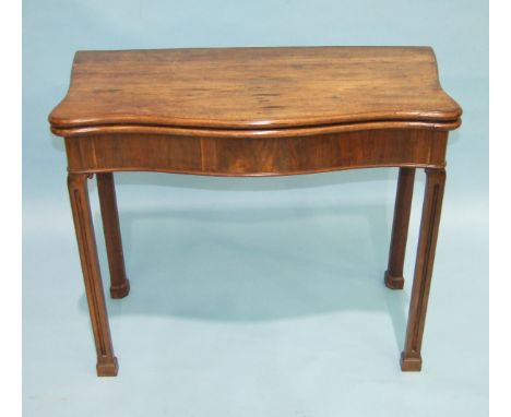 A Georgian mahogany serpentine fold-over card table, the top above a serpentine frieze, on fluted chamfered square legs, 91cm