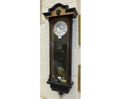 A late-19th century Vienna wall clock, the enamelled dial with Roman numerals, in stained wood case, 118cm high.