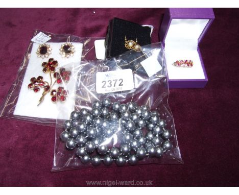 A pair of 9ct gold hallmarked earrings, a red and white stone gold coloured ring (unmarked), a red flower spray brooch and re