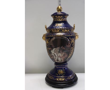 A large ceramic lidded urn on wooden base 