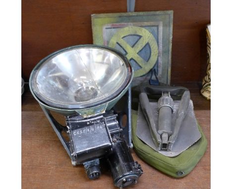 A military issue lamp marked Lamp Landing, a US folding spade and a plaque