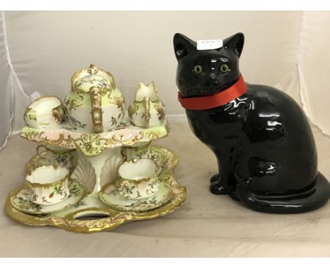 A tea tray incorporating four cups, teapot, creamer and sugar bowl (A/F); together with a large black cat figure