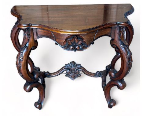 A REPRODUCTION MAHOGANY CONSOLE TABLE IN THE ROCOCCO STYLE, ornately carved with S scrolls and C scrolls. 