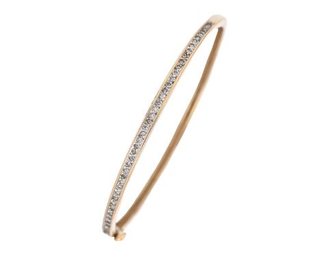 A diamond bangle, in 9ct gold, 58mm (internal), marks rubbed, 8.9g  Slight wear scratches