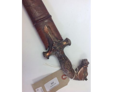 Indian style sword with copper washed grip in the design of a horse's head. Plain curved blade. In leather scabbard.