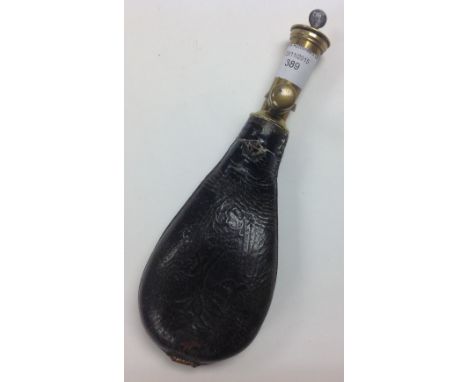 A 19th Century leather and brass gun powder flask having original lid incorporating measuring scoop.