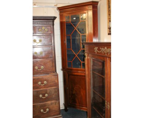 An Edwardian mahogany glazed corner cabinet with three shelves enclosed by astragal glazed panel door, on cupboard base and b