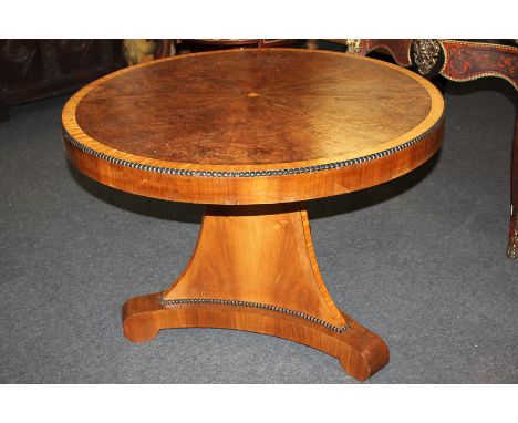 A walnut breakfast table with circular satinwood banded and tilting top, on triangular shaped pedestal and flat tripod base w