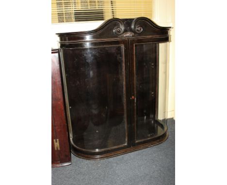 A mahogany display cabinet with scroll carved surmount and two curved panel glazed doors, 111cm, (a/f - lacks shelves)