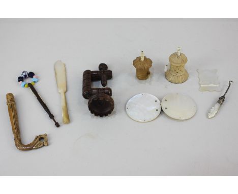 A collection of 19th century and later tape measures, a lace bobbin, a needlework clamp, a mother of pearl buckle, button hoo