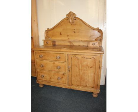 A pine chiffonier with scrolling foliate raised back, shelf and two drawers, the base with cupboard and drawers, on turned fe