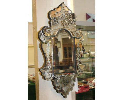 A Florentine style wall mirror with mirrored panel frame, floral decoration and crown surmount, 63cm by 35cm