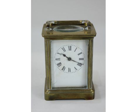 A brass and bevelled glass cased carriage clock, the white enamel dial with Roman numerals (a/f), 14cm