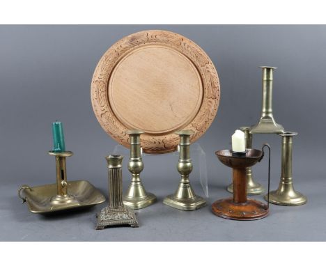 A carved oak bread board, 11 3/4" dia, two pairs of brass candlesticks, an Arts and Crafts style candlestick and other simila