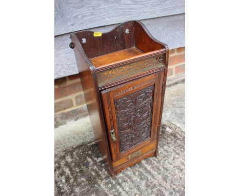 A smoker's Edwardian carved mahogany cabinet with gallery top, fitted interior and one drawer, 8 1/4" wide x 6 1/2" deep x 20