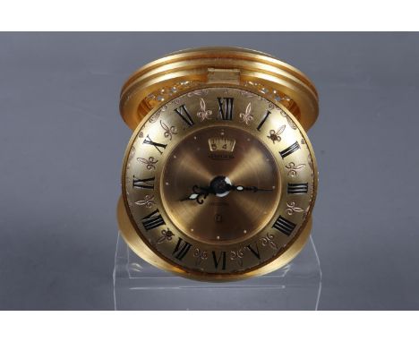 A Jaeger "Recital" eight-day travelling alarm clock, in gilt pierced metal case with gilt dial and Roman numerals, 2 3/4" dia