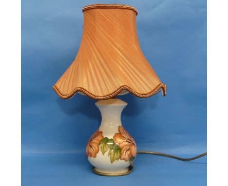 A Moorcroft 'Hibiscus' pattern Lamp, and shade, in cream ground with tube lined decoration, H25cm. 