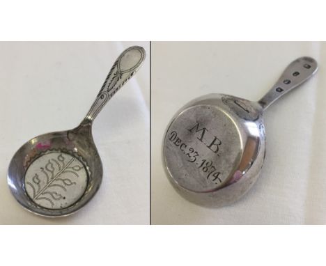 A Georgian silver flat bottomed caddy spoon. Hallmarked Birmingham 1799 with later engraving.