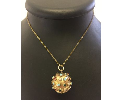 A 9ct gold orb pendant on a yellow metal chain.  Set with small pieces of coloured and milk glass of red, green, turquoise & 