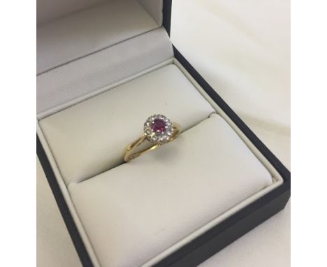 18ct gold ring set with a central ruby surrounded by diamonds in a platinum setting.  Size L1/2, total weight approx 2.9g