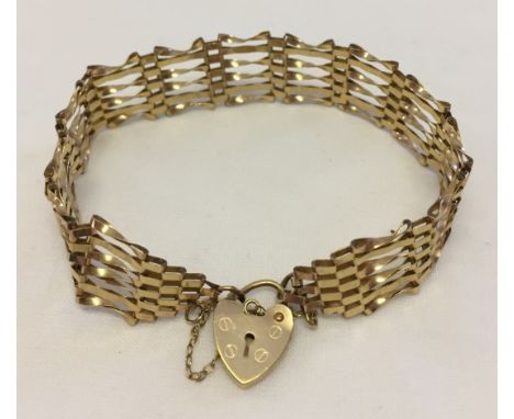 Hallmarked 9ct gold 6 bar gate bracelet with heart shaped 'padlock' clasp and safety chain. Total weight approx 7.1g.
