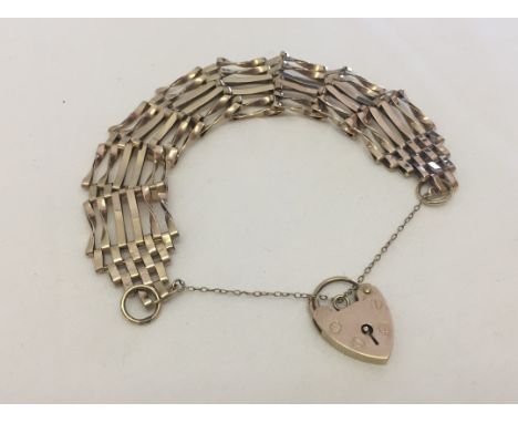 A 9ct gold 6 bar gate bracelet.  With 9ct gold heart shaped 'padlock' clasp and safety chain.  Weight approx 13.5g.