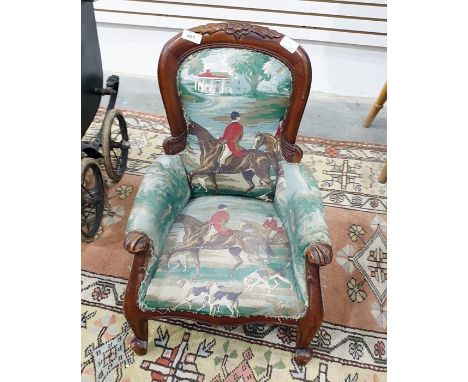 Child's Victorian style stained open armchair with floral carved toprail, upholstered in hunting scene fabric, on scroll supp