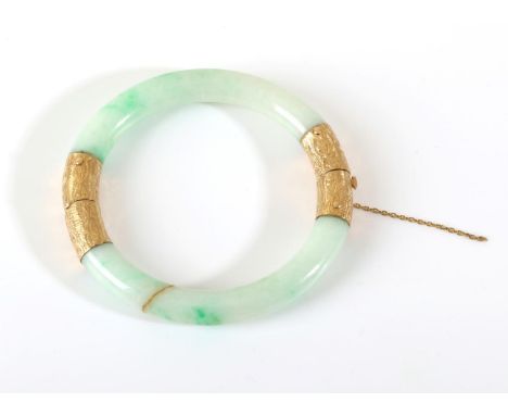 A Jade Bangle, with chased mounts, measures 6.5mm inner diameter .  The bangle is in good to fair condition, the jade is frac
