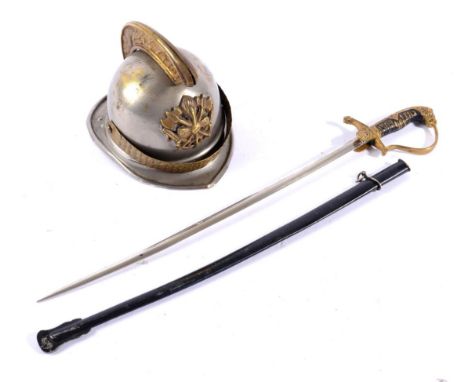 A German Brass and Silver Plate Inkwell, modelled as a miniature fireman's helmet, 7cm; and A Paper Knife, modelled as a dres