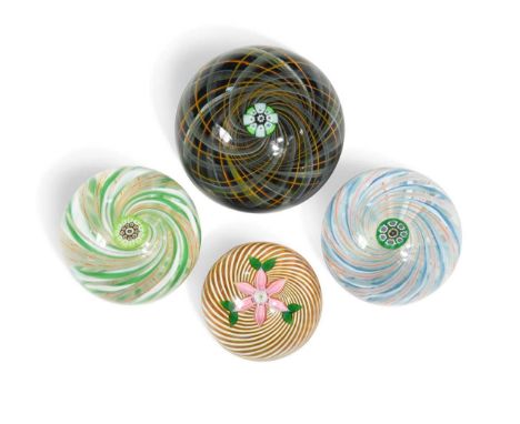 A collection of four Perthshire glass swirl paperweights, the largest with a swirling arrangement of latticino canes in a com