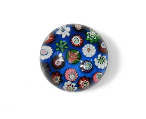 A small Clichy spaced millefiori glass paperweight, with an arrangement of two concentric bands of canes radiating around a c