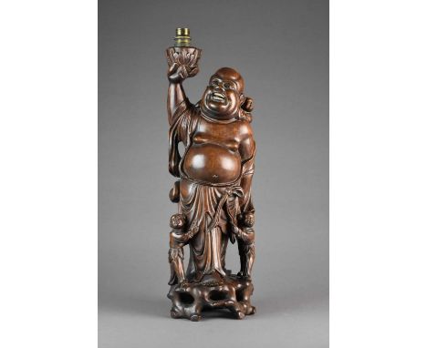 A Chinese carved hardwood laughing Buddha table lamp, 20th centuryModelled standing and accompanied by three children, 47cm h