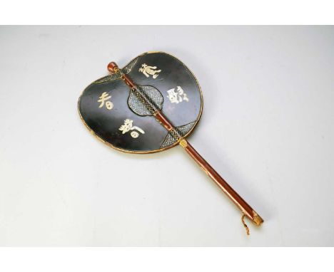 A Chinese lacquer fan or handheld fire screen, late Qing Dynasty, of oval profile on a plain handle, to one side decorated wi