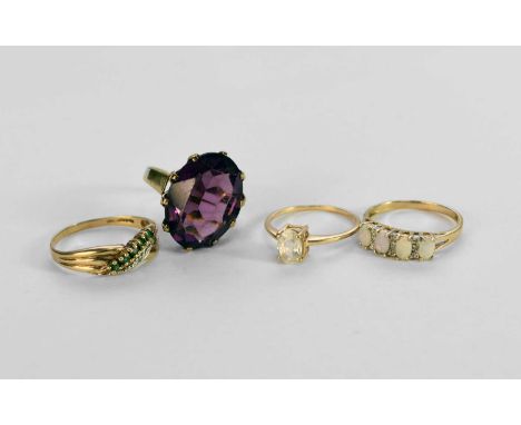 A 9ct gold opal ring, size P, together with a 9ct gold emerald and diamond ring, size T, a purple paste set ring, the yellow 